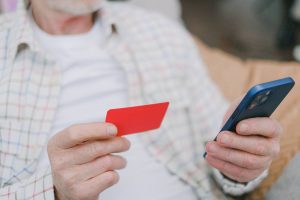 Como saber si tengo deudas. Imagen de una persona sosteniendo una tarjeta de crédito