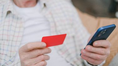 Como saber si tengo deudas. Imagen de una persona sosteniendo una tarjeta de crédito