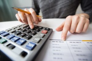 Closeup of Accountant Hands Counting on Calculator