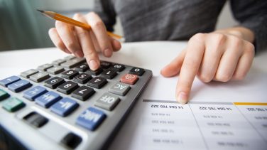 Closeup of Accountant Hands Counting on Calculator