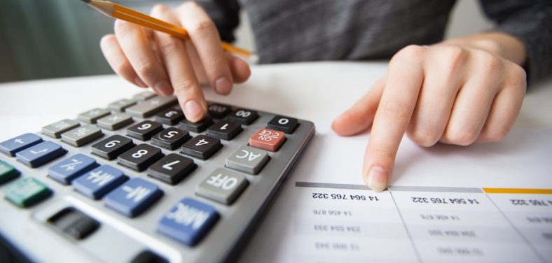 Closeup of Accountant Hands Counting on Calculator