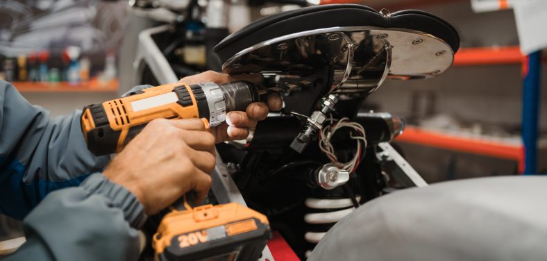 Un hombre arregla una motocicleta.
