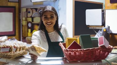 Waitress giving parcel at counter in cafe