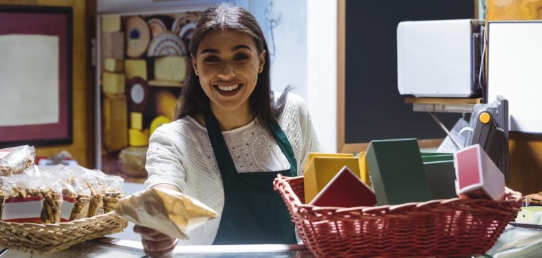 Waitress giving parcel at counter in cafe