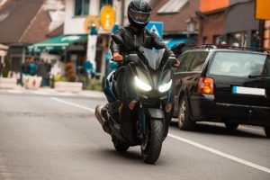 ¿Como prevenir el robot de motos? Imagen: Moto negra con piloto conduciendo en la calle