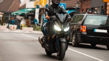 ¿Como prevenir el robot de motos? Imagen: Moto negra con piloto conduciendo en la calle