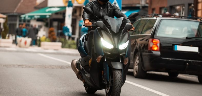 ¿Como prevenir el robot de motos? Imagen: Moto negra con piloto conduciendo en la calle