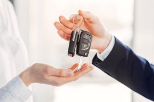 Woman buying the car. Lady in a car salon. Manager with a client