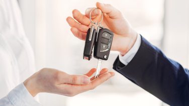 Woman buying the car. Lady in a car salon. Manager with a client